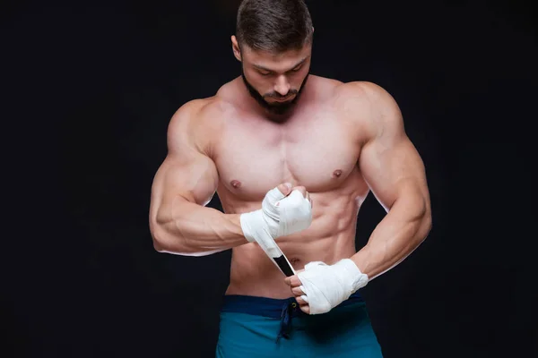 Muscular Fighter kickbox With white Bandages against the black background. — Stock Photo, Image