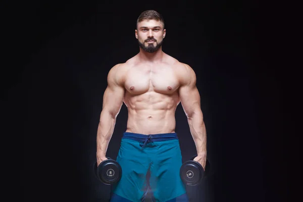 Muskulös bodybuilder killen gör övningar med hantel över svart bakgrund — Stockfoto