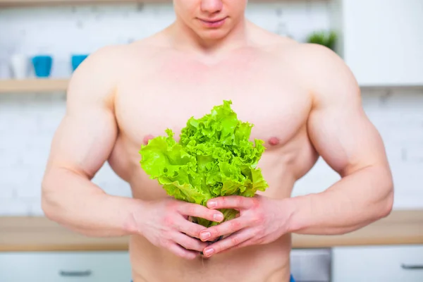 Uomo muscoloso con busto nudo in cucina con insalata, concetto di alimentazione sana. Stile di vita atletico . — Foto Stock
