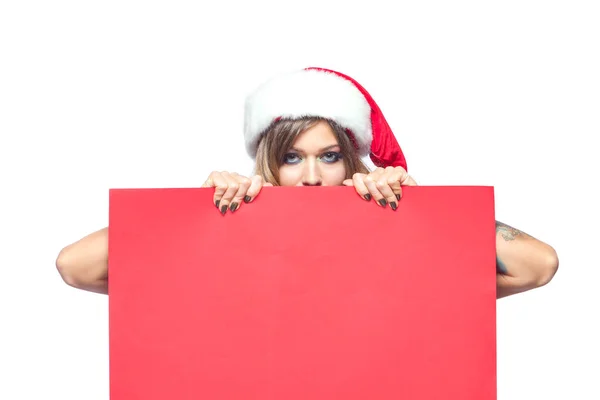 Til jul. Vakker, muskuløs, seksuell lykkelig kvinne i julenisseklær. Holder seg blank på tavla. Isolert på hvit bakgrunn . – stockfoto
