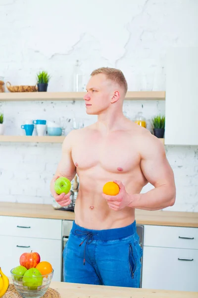 フルーツ、健康的な食事の概念とキッチンで裸の胴体の筋肉男。生活の運動方法. — ストック写真