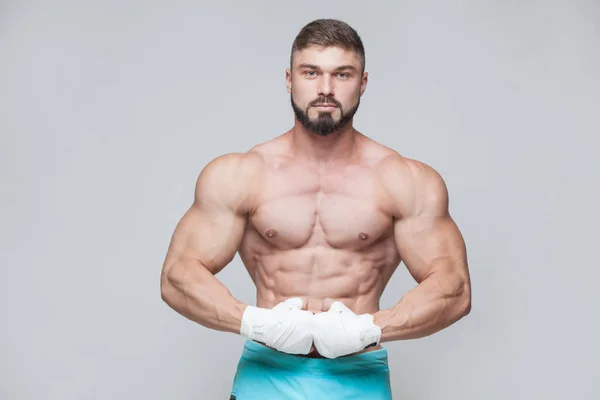 Muscular Fighter kickbox con fasciature bianche sullo sfondo grigio — Foto Stock