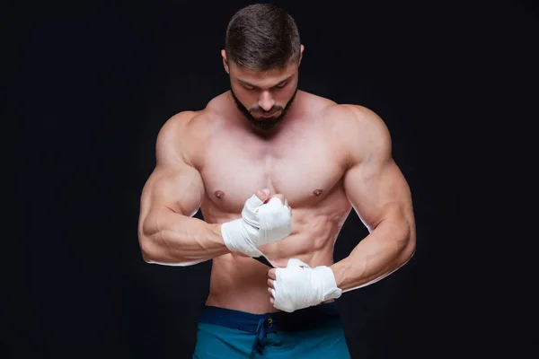 Muskulös Fighter kickbox med vitt bandage mot svart bakgrund. — Stockfoto