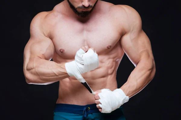 Muscular Fighter kickbox con vendajes blancos contra el fondo negro . — Foto de Stock