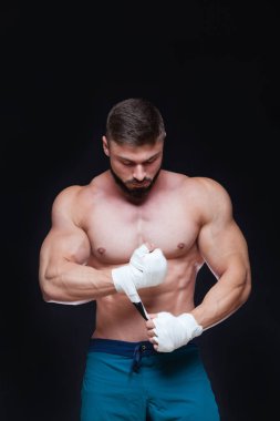 Siyah arka plan beyaz bandaj ile kaslı savaşçı kickbox.