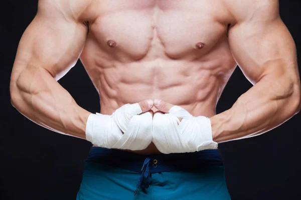 Muskulöser Kämpfer-Kickbox mit weißen Binden vor schwarzem Hintergrund. — Stockfoto