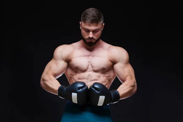 Forte boxeador muscular em luvas de boxe preto. Isolado em fundo preto . — Fotografia de Stock