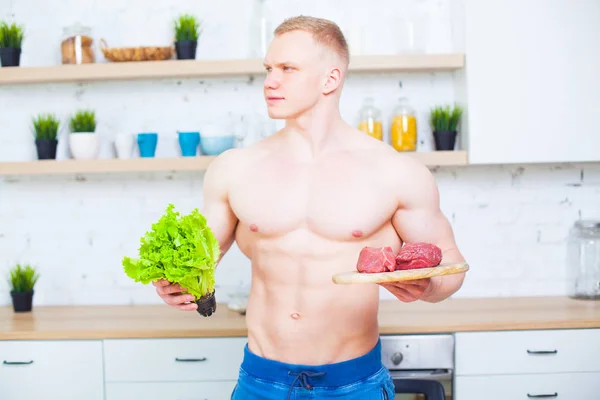 Svalnatý muž nahý trup v kuchyni se salátem a kousek hovězího masa, koncept zdravé stravy. Sportovní způsob života. — Stock fotografie