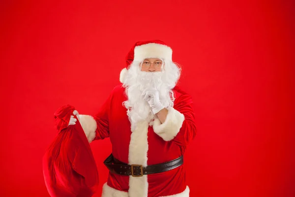 Noël. Portrait du Père Noël avec un énorme sac rouge gardant index par — Photo