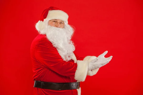 Père Noël pointant à blanc un endroit, fond rouge — Photo