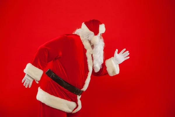 Weihnachten. Laufen Weihnachtsmann roter Hintergrund frohe Weihnachten. — Stockfoto