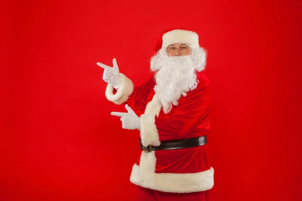 Santa Claus señalando en blanco un lugar, fondo rojo — Foto de Stock