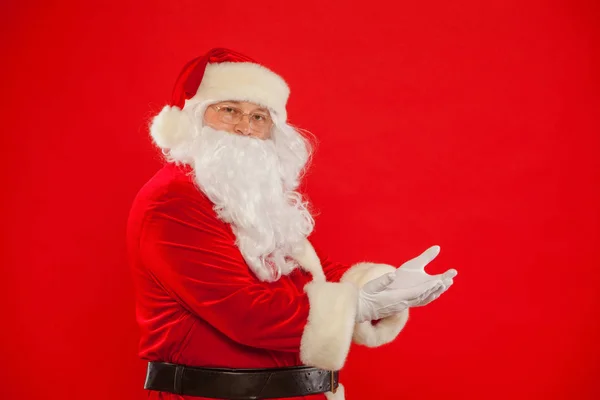 Weihnachten. Weihnachtsmann zeigt auf einen leeren Platz, roter Hintergrund — Stockfoto