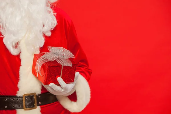 Foto von Santa Claus behandschuhten Händen mit roter Geschenkbox — Stockfoto