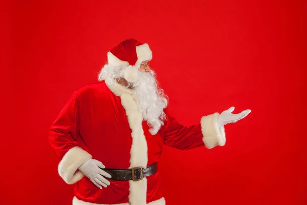 Weihnachtsmann zeigt auf einen leeren Platz, roter Hintergrund — Stockfoto