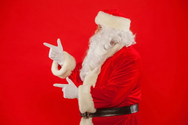 Santa Claus señalando en blanco un lugar, fondo rojo —  Fotos de Stock