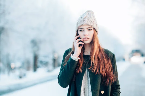 Fiatal nő, mosolygós, szúró telefon és a téli táj . — Stock Fotó