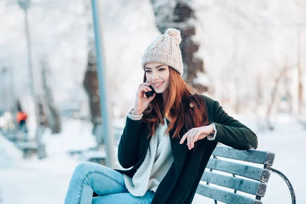 Fiatal nő, mosolygós, szúró telefon és a téli táj . — Stock Fotó