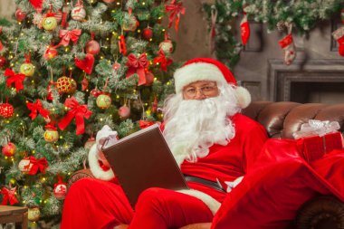 Noel Baba bir rahat sandalye ve READI evinde oturan