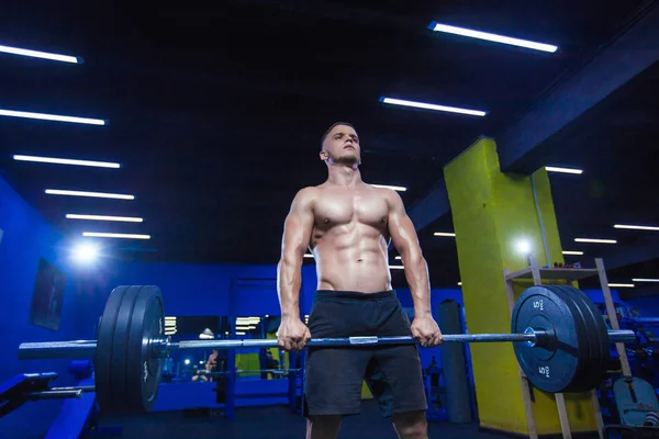 Muskularny mężczyzna trening ze sztangą, siłowni. Brutalne kulturysta lekkoatletycznego mężczyzna z doskonałe abs, barki, biceps, triceps i klatki piersiowej. Ćwiczenie sztanga Dead lift — Zdjęcie stockowe