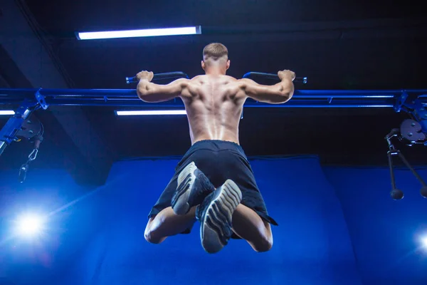 Fitness mannen göra pull-ups i ett gym för en back workout bakifrån — Stockfoto