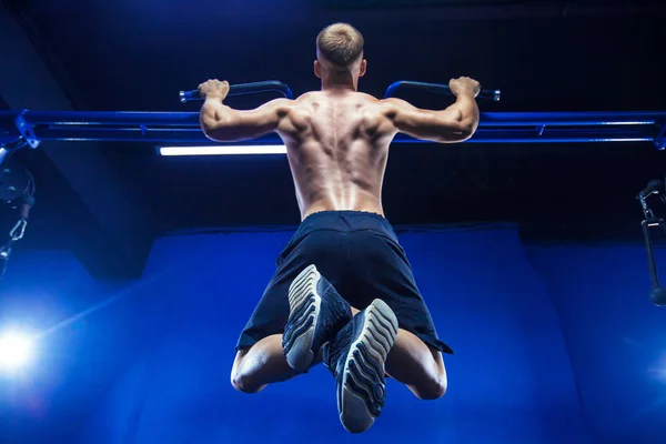 Γυμναστήριο άνδρας κάνει pull-ups σε ένα γυμναστήριο με θέα στην πίσω πλάτη προπόνηση — Φωτογραφία Αρχείου