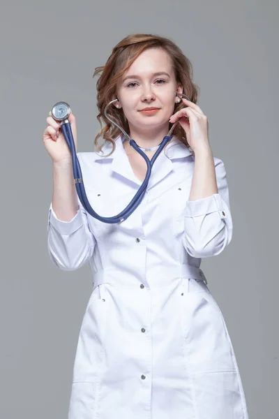 Female doctor with stethoscope standing and looking at camera — Stock Photo, Image