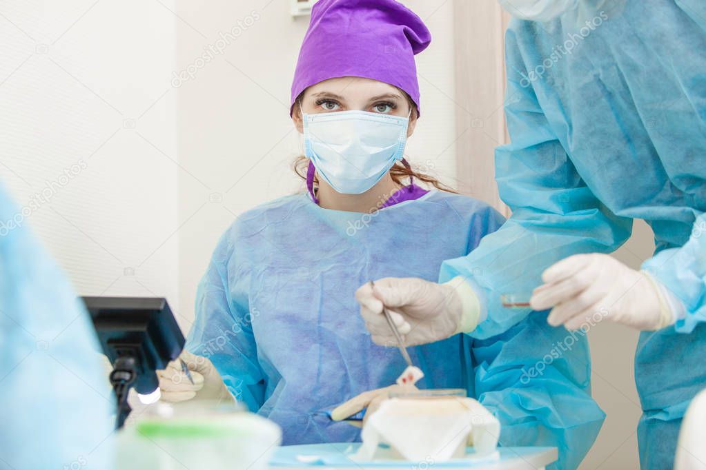 The doctor under the microscope recalculates the hair follicles. Baldness treatment. Hair transplant. Surgeons in the operating room carry out hair transplant surgery. Surgical technique that moves