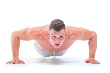 Spor adam beyaz bir arka planda izole Push UPS yapıyor. Güçlü atletik adam-Fitness modeli onun mükemmel vücudu gösteren.