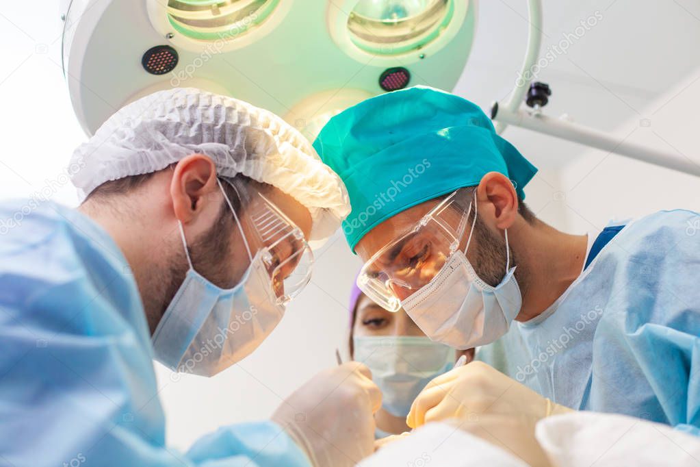 Baldness treatment. Hair transplant. Surgeons in the operating room carry out hair transplant surgery. Surgical technique that moves hair follicles from a part of the head.