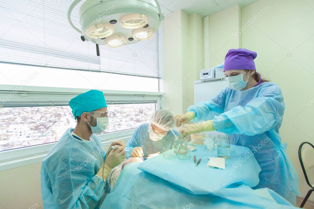 Baldness treatment. Hair transplant. Surgeons in the operating room carry out hair transplant surgery. Surgical technique that moves hair follicles from a part of the head.