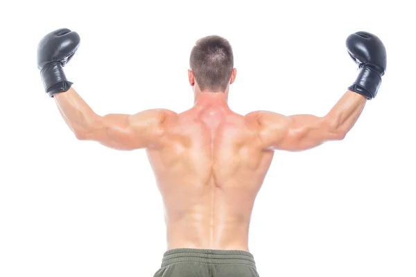 Gespierde jonge man in zwarte bokshandschoenen en shorts toont de verschillende bewegingen en stakingen in de studio op een witte achtergrond. Sterk atletisch man-fitness model dat zijn perfecte lichaam toont. Kopiëren — Stockfoto