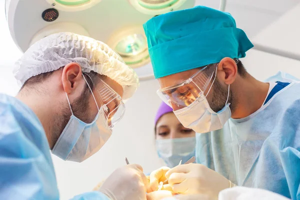 Skallighet behandling. Hårtransplantation. Kirurger i operationssalen utför hår transplantationskirurgi. Kirurgisk teknik som flyttar hårsäckarna från en del av huvudet. — Stockfoto