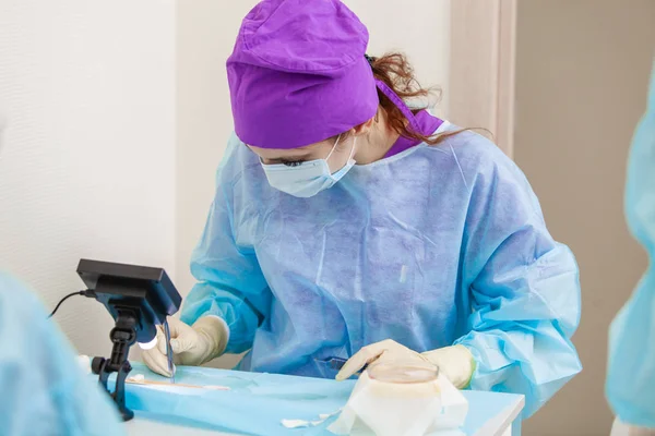 Läkaren under mikroskopet beräknar om hår säckarna. Skallighet behandling. Hår transplantation. Kirurgisk teknik som flyttar hår säckarna från en del av huvudet. — Stockfoto