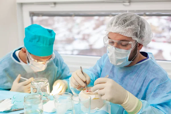 Baldness treatment. Hair transplant. Surgeons in the operating room carry out hair transplant surgery. Surgical technique that moves hair follicles from a part of the head.