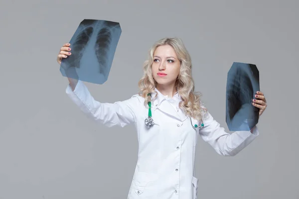Giovane medico donna guardando l'immagine a raggi X dei polmoni — Foto Stock