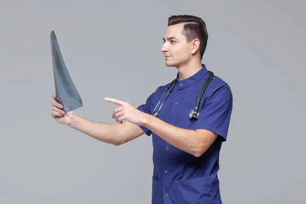 Young male doctor studying the x-ray picture of lungs — Stock Photo, Image