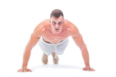 Spor adam beyaz bir arka planda izole Push UPS yapıyor. Güçlü atletik adam-Fitness modeli onun mükemmel vücudu gösteren.