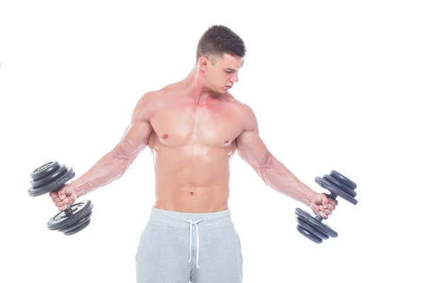 ダンベルを持つハンサムなパワーアスレチックマンは自信を持って前を向いている。6パック、完璧な腹筋、肩、二頭筋、三頭筋と胸を持つ強力なボディービルダー。強いアスレチックマン - フィットネスモデルを示す — ストック写真