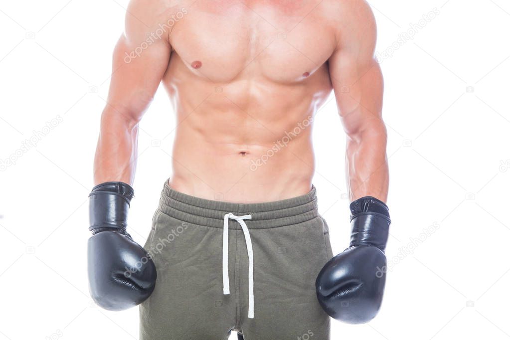 Muscular young man in black boxing gloves and shorts shows the different movements and strikes in the studio on a white background. Strong Athletic Man - Fitness Model showing his perfect body. Copy