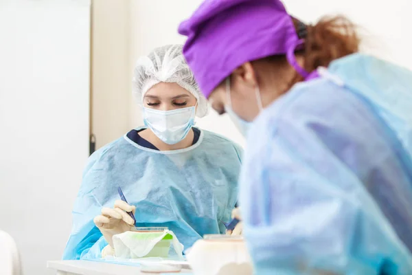 The doctor under the microscope recalculates the hair follicles. Baldness treatment. Hair transplant. Surgical technique that moves hair follicles from a part of the head. — Stock Photo, Image