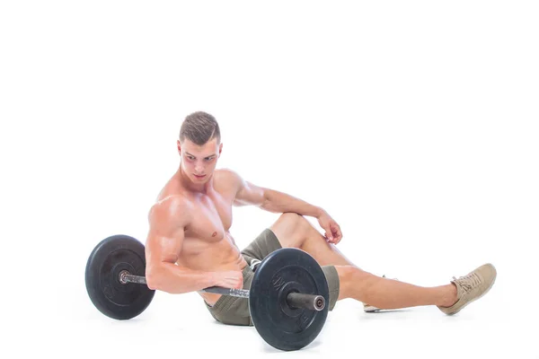 Homem musculoso trabalhando fora no estúdio fazendo exercícios com barra no bíceps, abdominais fortes tronco nu masculino. Isolado em fundo branco. Espaço Copiar. Descanse, senta-se no chão à campainha. Fadiga . — Fotografia de Stock