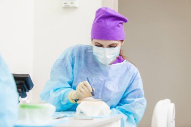 Mikroskop altındaki Doktor saç folikülleri yeniden hesaplıyor. Kellik tedavisi. Saç nakli. Kafa bir kısmından saç folikülleri hareket eden cerrahi tekniği.