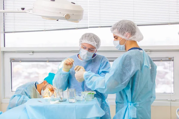 Skallighet behandling. Hårtransplantation. Kirurger i operationssalen utför hår transplantationskirurgi. Kirurgisk teknik som flyttar hårsäckarna från en del av huvudet. — Stockfoto
