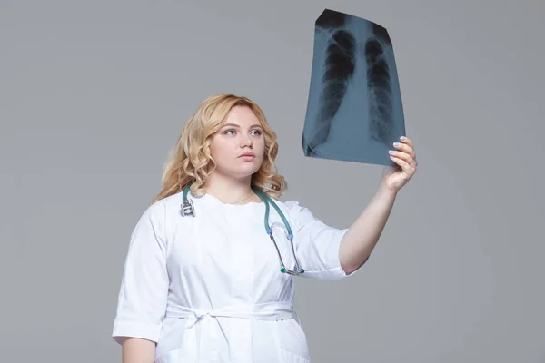 Giovane medico donna guardando l'immagine a raggi X dei polmoni . — Foto Stock