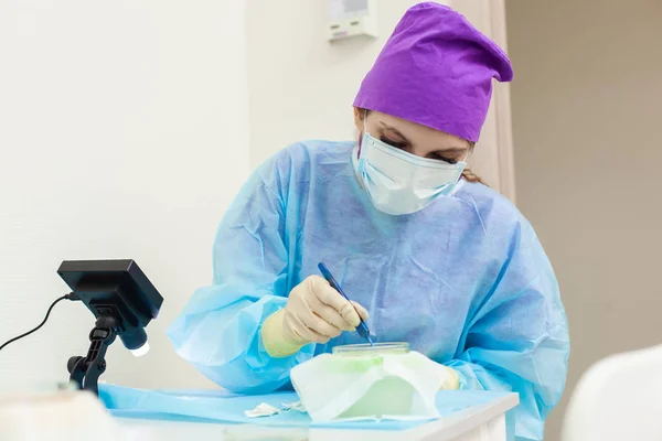 Läkaren under mikroskopet beräknar om hår säckarna. Skallighet behandling. Hår transplantation. Kirurgisk teknik som flyttar hår säckarna från en del av huvudet. — Stockfoto