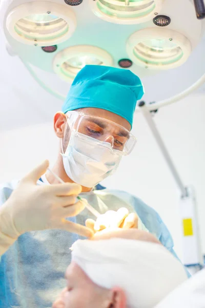 The surgeon gives injections to the head. Baldness treatment. Hair transplant. Surgeons in the operating room carry out hair transplant surgery. Surgical technique that moves hair follicles from a — Stock Photo, Image