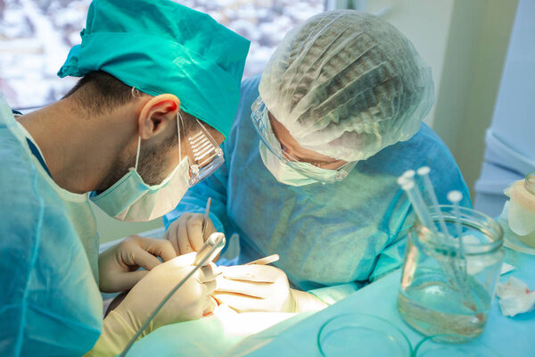 Baldness treatment. Hair transplant. Surgeons in the operating room carry out hair transplant surgery. Surgical technique that moves hair follicles from a part of the head.