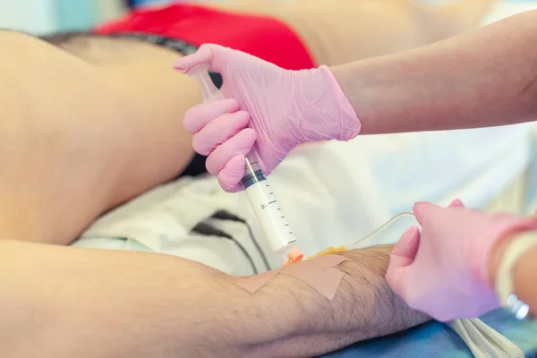 Förberedelse för kirurgi. Medicinsk sjuksköterska med rosa latex handskar ingångar kateter till ven patient för dropp av kemoterapi eller annan flytande medicin, jektion av propofol till patient för IV anestesi. — Stockfoto