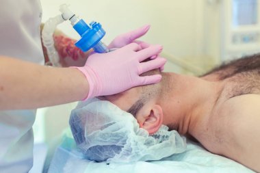 Anestezist operasyon odasında trakeal entübasyonu yapıyor. Ameliyat hazırlığı. Rinoplasti